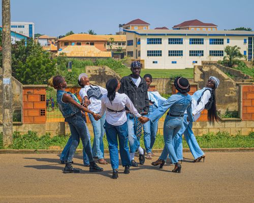 Free A vibrant group of youths dancing outdoors in a circle under a clear sky, showcasing joy and unity. Stock Photo