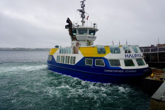 The Christopher Stannix ferry navigating the waters at Halifax harbor on a cloudy day.