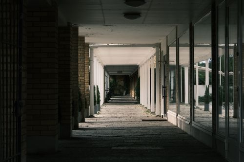 Free A modern corridor with glass reflections and moody lighting, perfect for architectural stock photos. Stock Photo