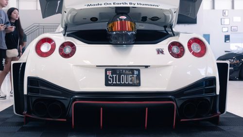 Free Rear view of a Nissan GT-R with a unique license plate and helmet in the trunk, indoors. Stock Photo