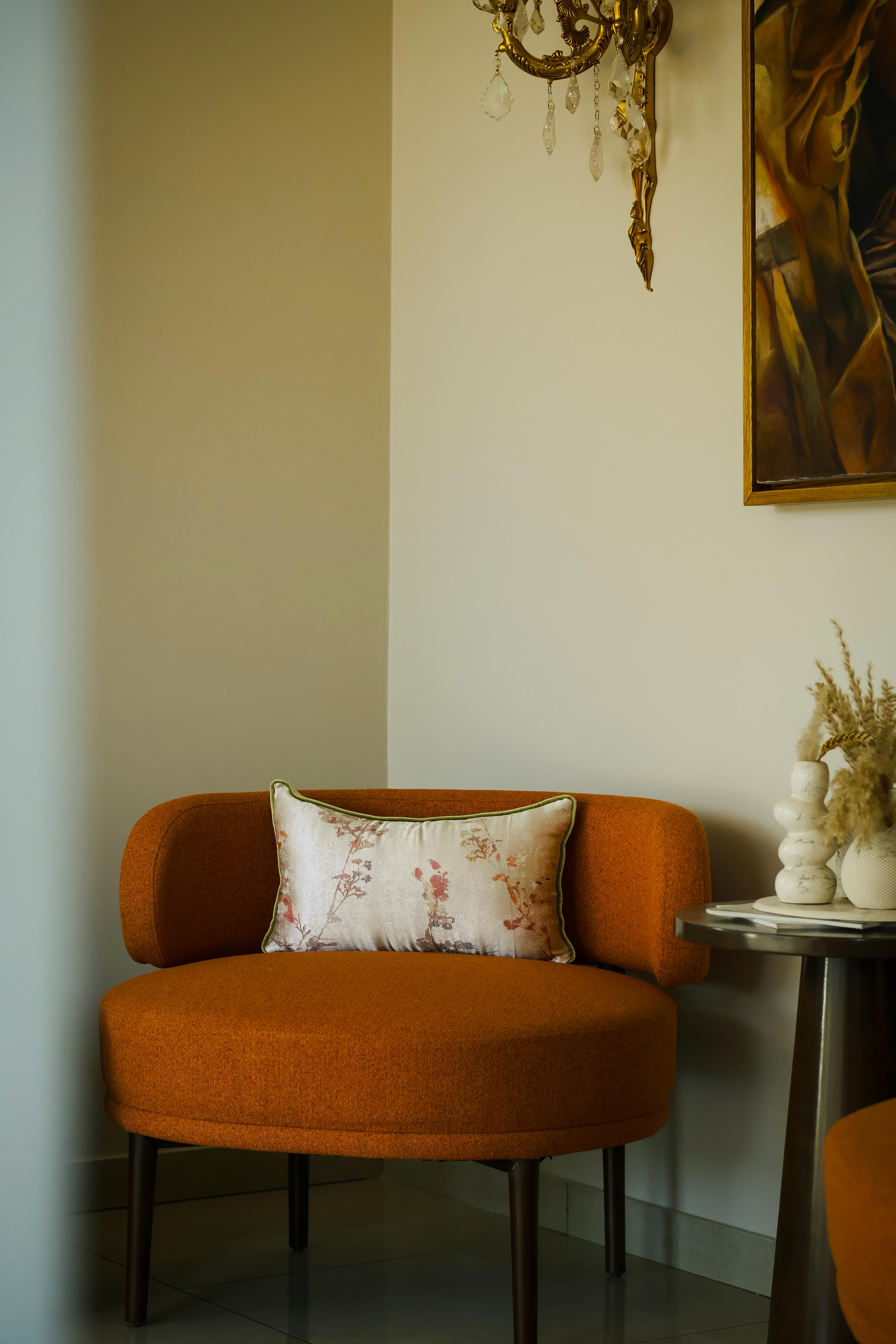 Free Elegant orange armchair with decorative pillow in a stylish interior setting. Stock Photo