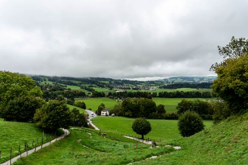 Free Picturesque view of lush green pastures and rolling hills in Gruyères, Switzerland. Stock Photo
