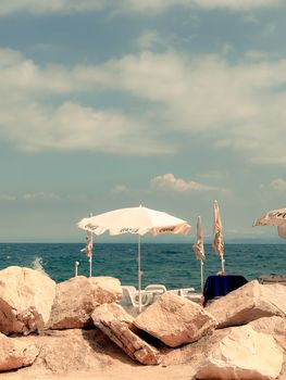 Peaceful beach with empty lounge chairs and umbrellas by the sea, a tranquil escape.