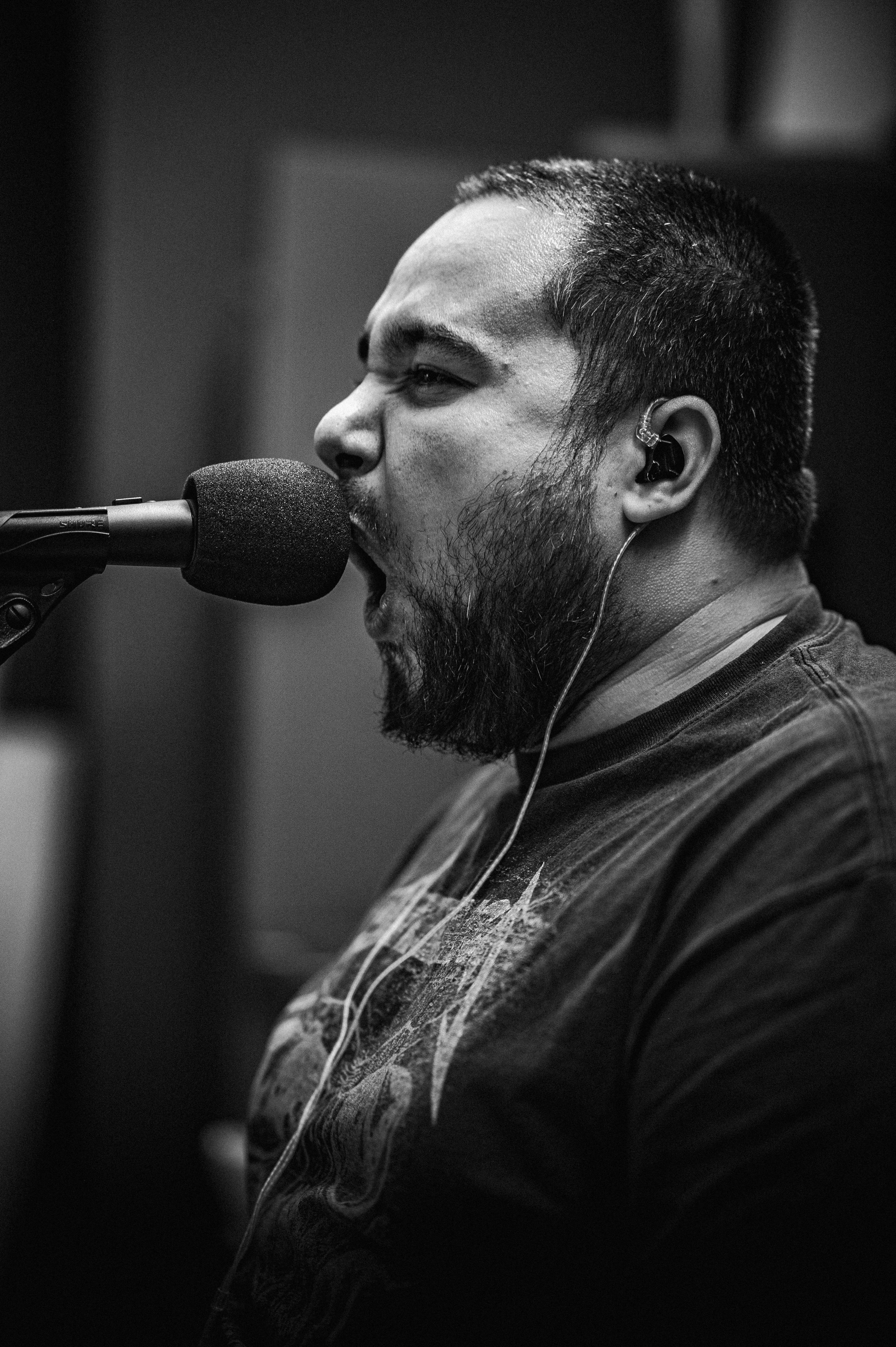 Emotional black and white portrait of a singer passionately performing into a microphone.