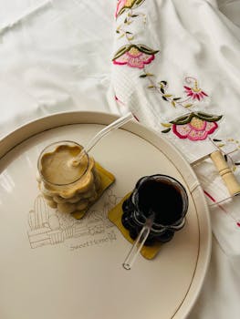 Elegant coffee drinks on a stylish tray with embroidered cloth, perfect for cozy mornings.
