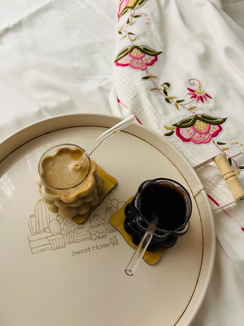 Free Elegant coffee drinks on a stylish tray with embroidered cloth, perfect for cozy mornings. Stock Photo