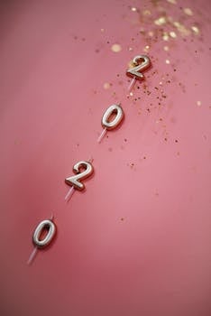 粉红色的表面点缀着金色五彩纸屑，形成了2020年的蜡烛，营造出节日与庆祝的氛围