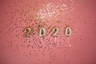 粉色背景搭配2020年蜡烛和金色闪光，非常适合派对主题