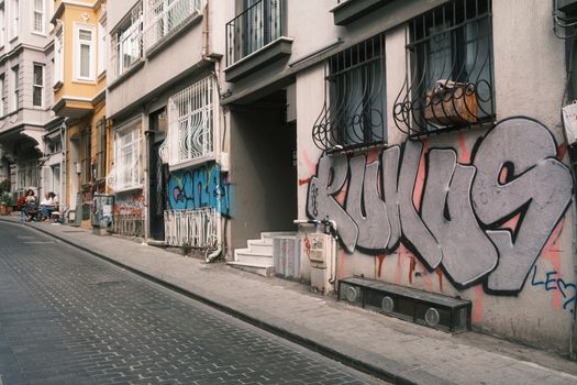 Vibrant street scene featuring modern graffiti on historic buildings in an urban neighborhood.