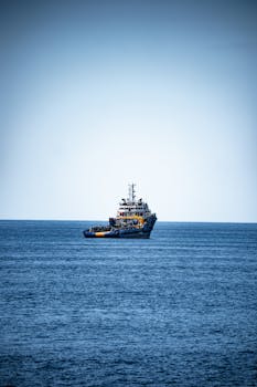 A solitary tugboat navigates calm waters under a clear blue sky in Istanbul, Turkey.