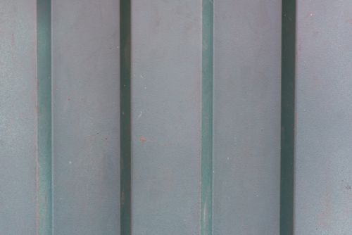 Free Detailed close-up of a weathered metal surface featuring vertical shadows. Stock Photo