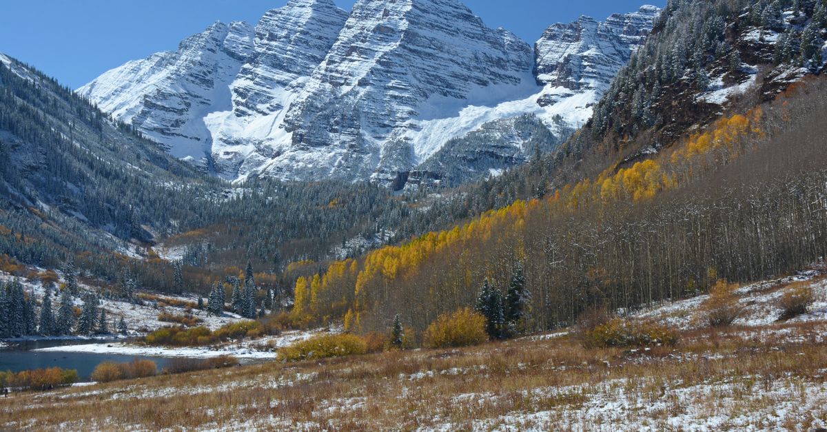 Breathtaking view of Maroon Bells with autumn foliage and snow near Snowmass, Colorado.