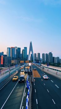 A vivid view of Chongqing's cityscape featuring a modern bridge at dusk.