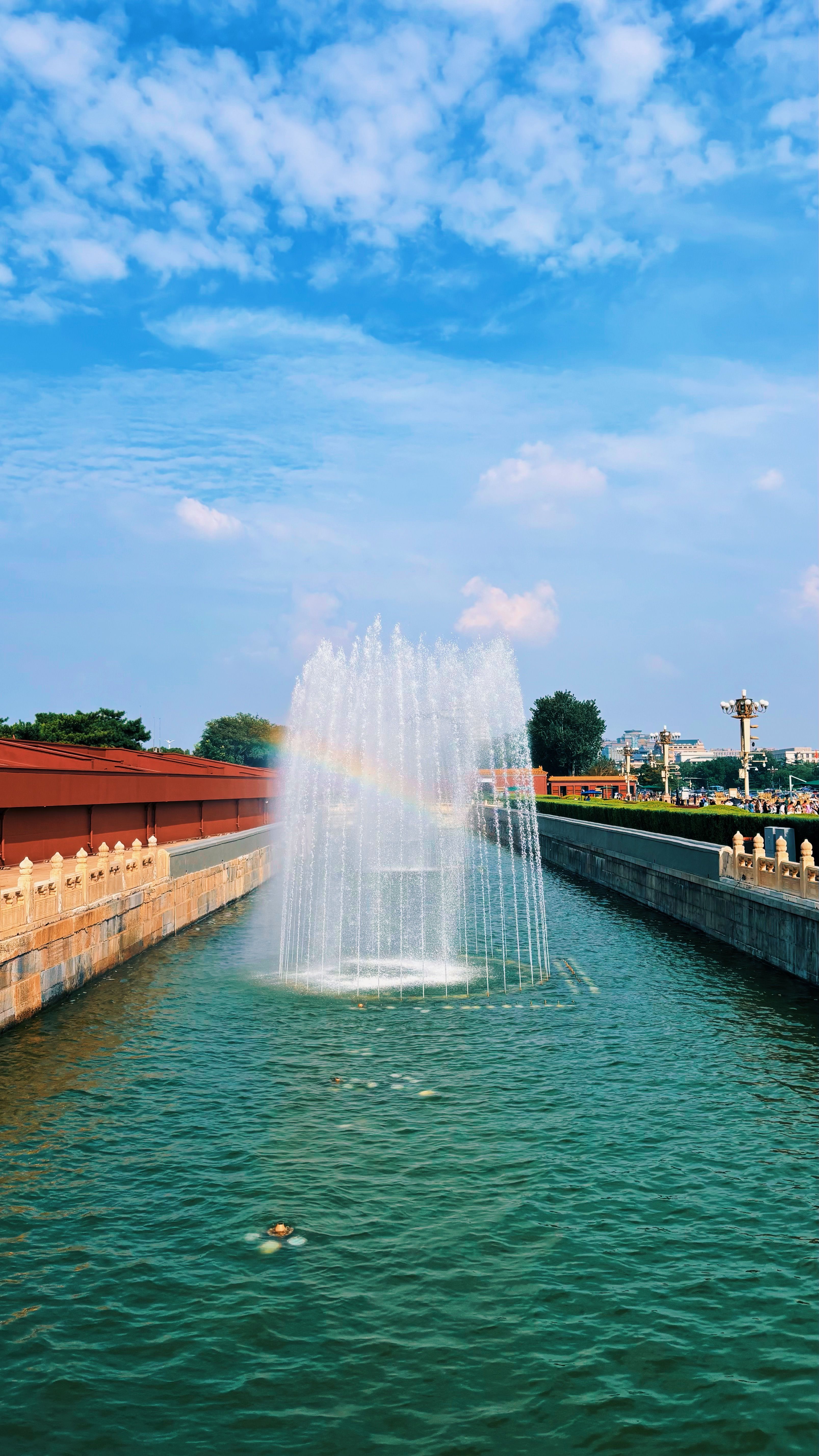 A beautiful fountain with a rainbow in the Forbidden City, Beijing, on a sunny day.