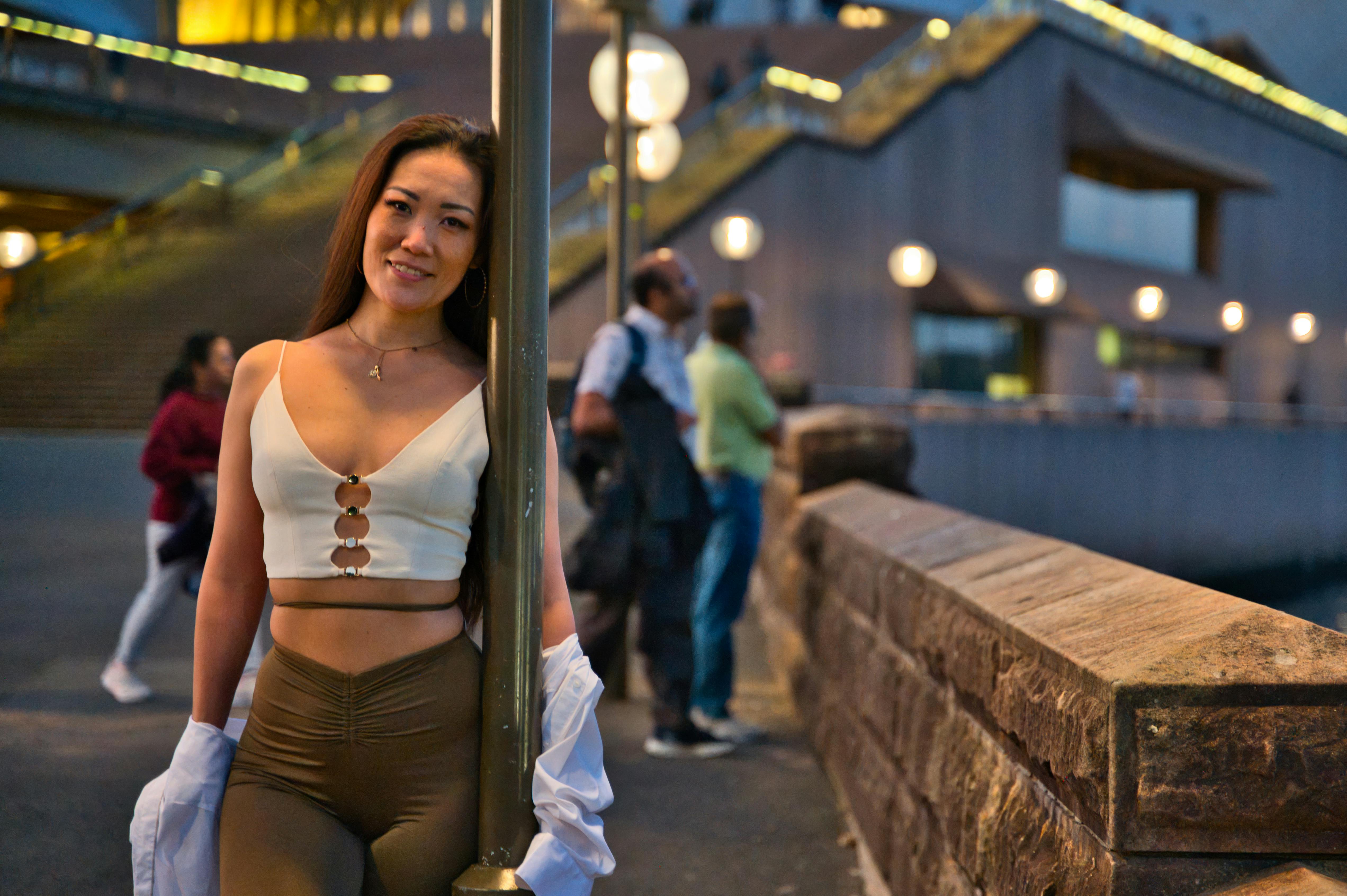 Artistic portrait of a woman near the iconic Sydney Opera House at sunset.
