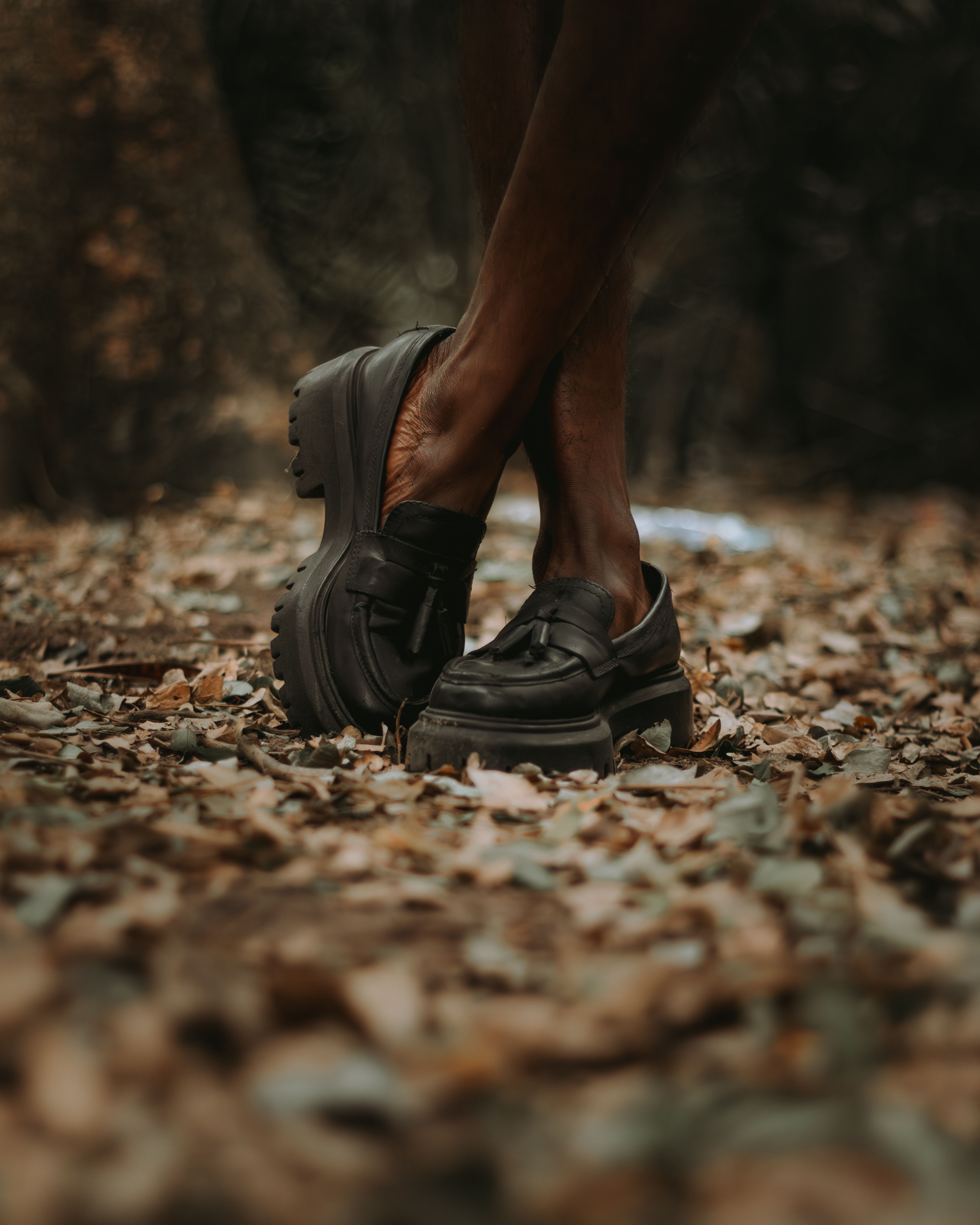 Crossed Legs on Autumn Leaf-Covered Ground · Free Stock Photo