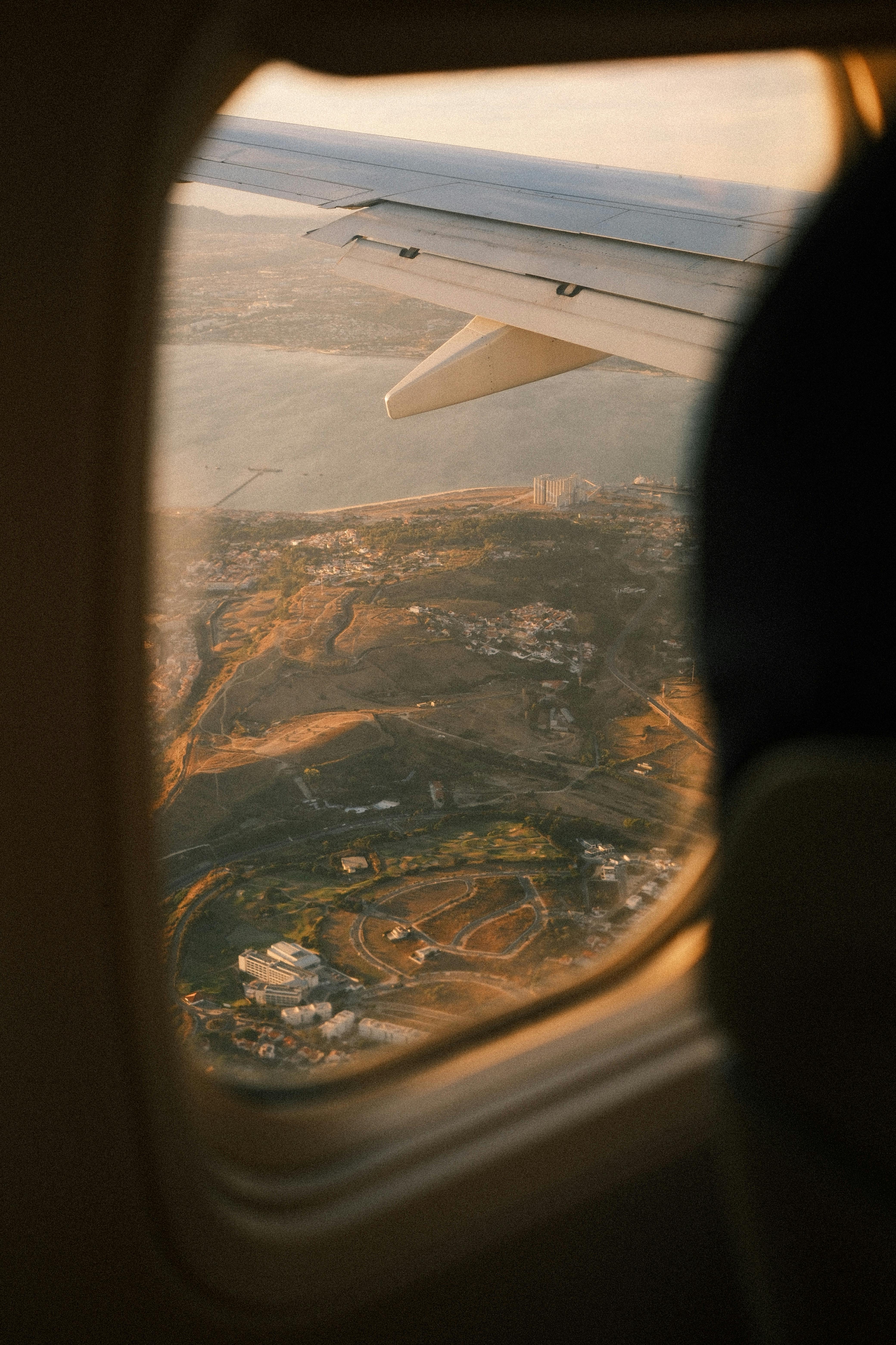 Stunning aerial view from an airplane over Lisbon, Portugal during sunset, showcasing its landscapes.