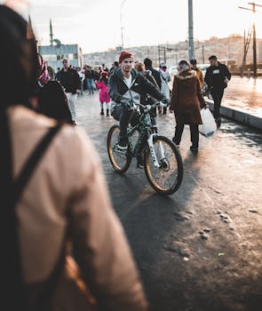 日落时分，一个骑自行车的人穿过一条繁忙的城市街道，周围都是行人