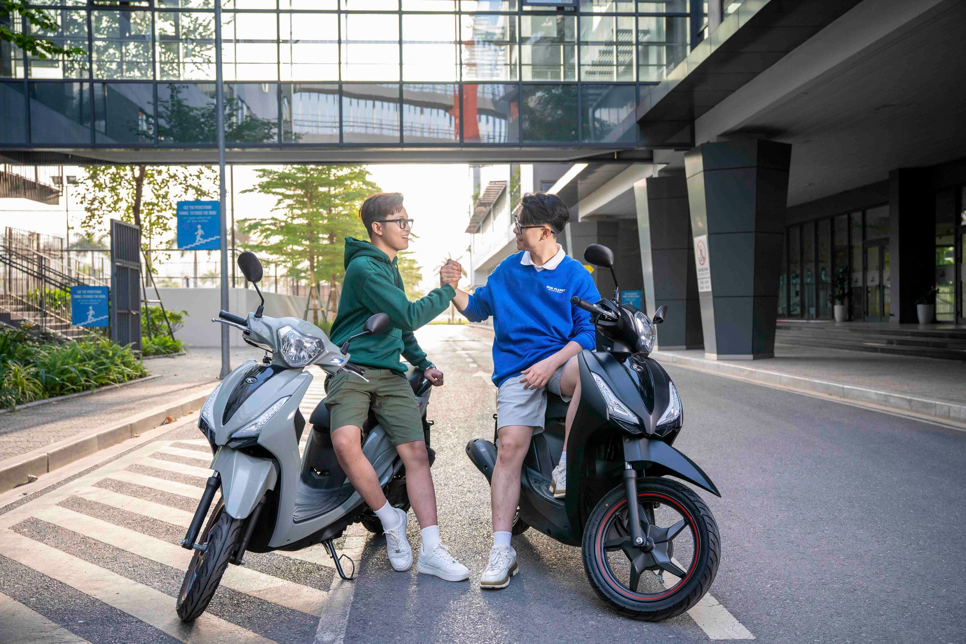 Two young men on scooters meet in a vibrant urban setting in Vietnam. Friendship and modern lifestyle.