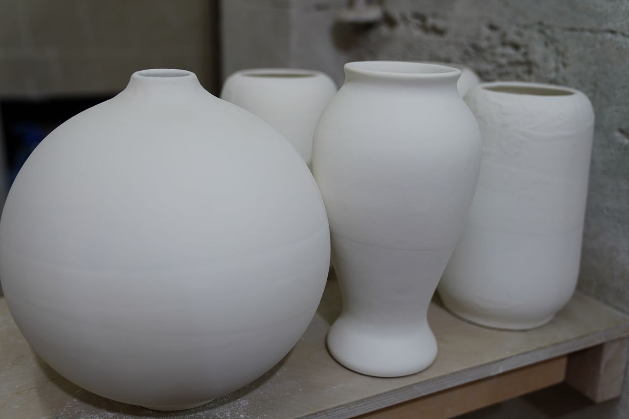 White ceramic vases arranged on a shelf, photo by Tahir Xelfequliyev on Pexels