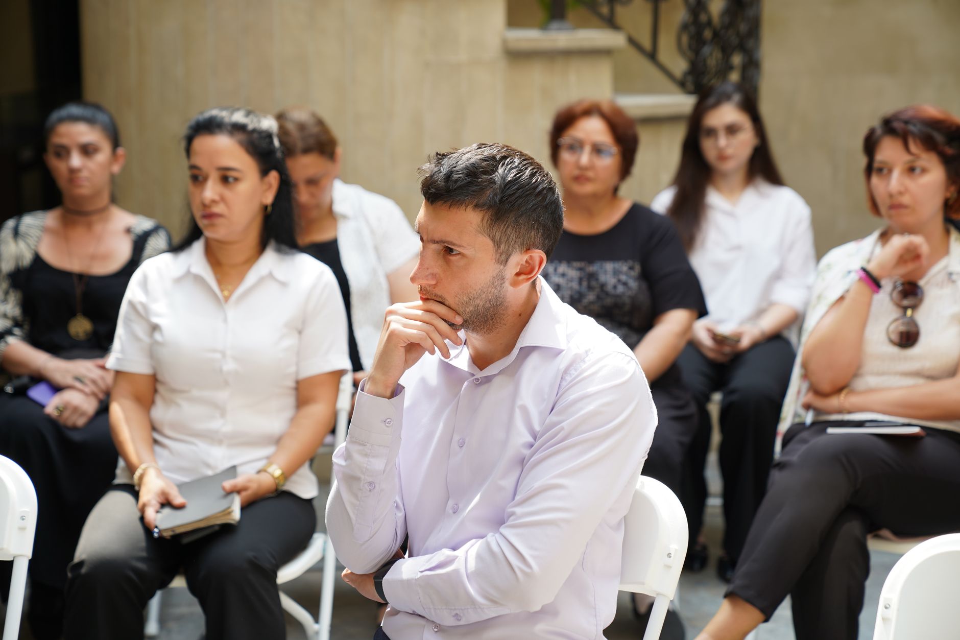 Group of people engaged in a business meeting discussion outdoors.