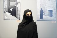 Woman in niqab attending a contemporary art exhibition indoors.