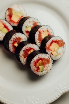 Delicious salmon sushi rolls with avocado and rice on an elegant plate.