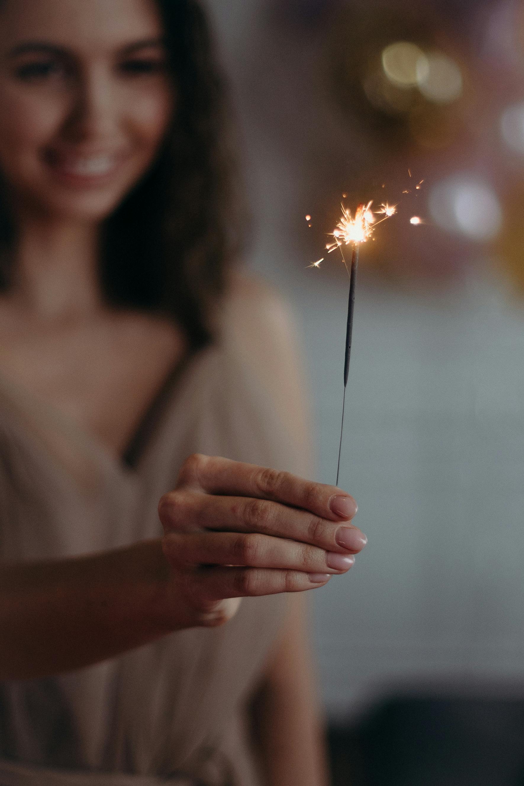 shallow focus photo of woman holding sparkle