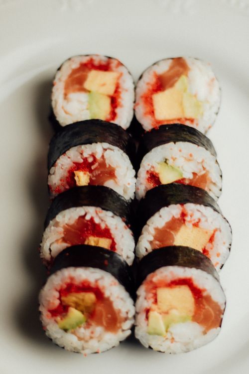 Free A plate of neatly arranged salmon and avocado sushi rolls, perfect for seafood lovers. Stock Photo