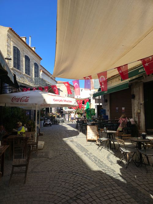Free Cozy outdoor cafe in a Turkish street full of vibrant flags on a sunny day. Stock Photo