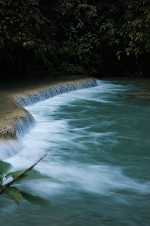 Free Peaceful waterfall surrounded by dense forest, captured with long exposure for a dreamy effect. Stock Photo