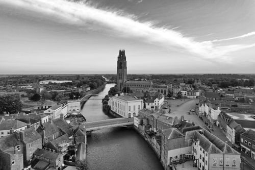 Free Black and white aerial view of the iconic Boston Stump Tower in Lincolnshire, England, along a serene river. Stock Photo