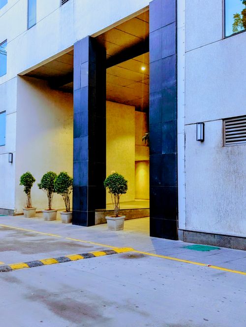 Free Contemporary building entrance with sleek design and potted plants providing a green touch. Stock Photo