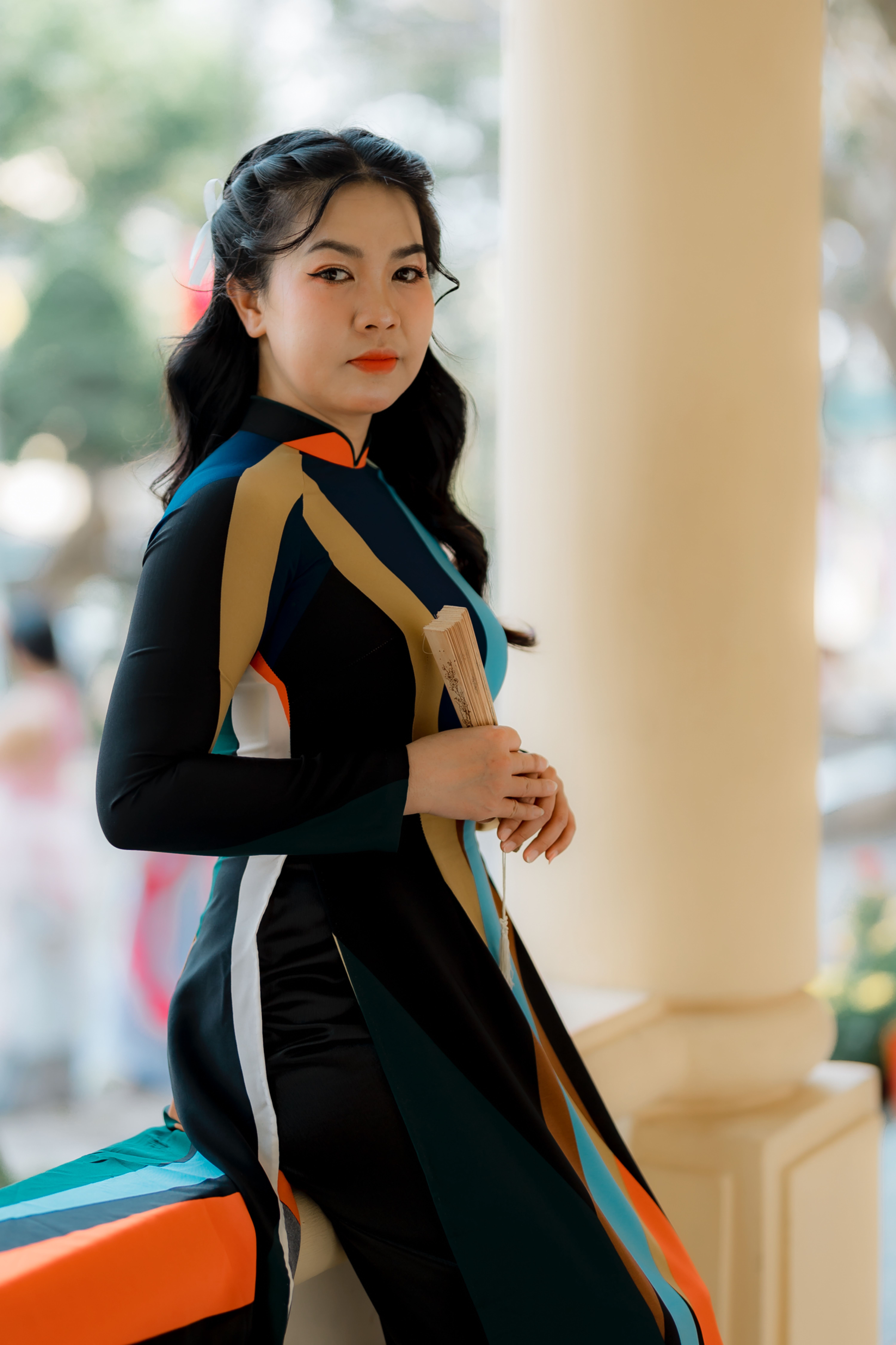 Elegant woman wearing a modern Ao Dai dress outdoors, exuding confidence and cultural style.
