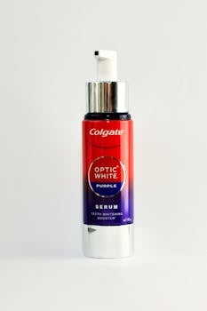 Colgate Optic White Purple Serum bottle on a white background.