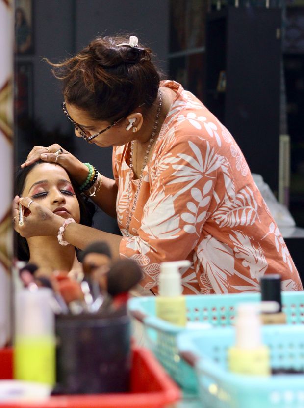 Beautician applying makeup to a seated client