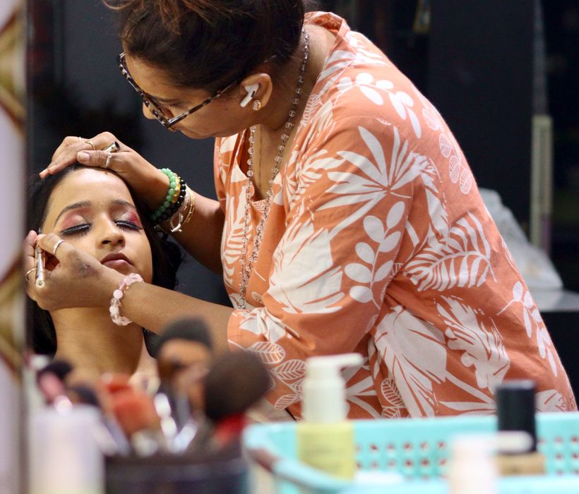 Beautician applying makeup to a seated client