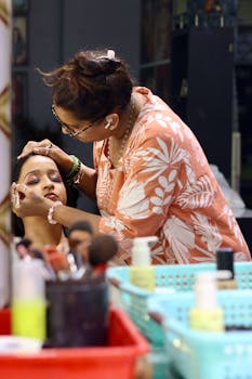 Makeup artist diligently applying beauty makeup to a woman in a salon setting.