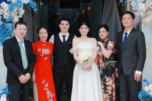 A joyful outdoor wedding ceremony featuring the bride with her family, beautifully dressed for the occasion.