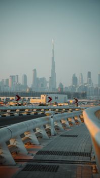 Stunning sunrise view of Burj Khalifa and Dubai skyline from a curved road.