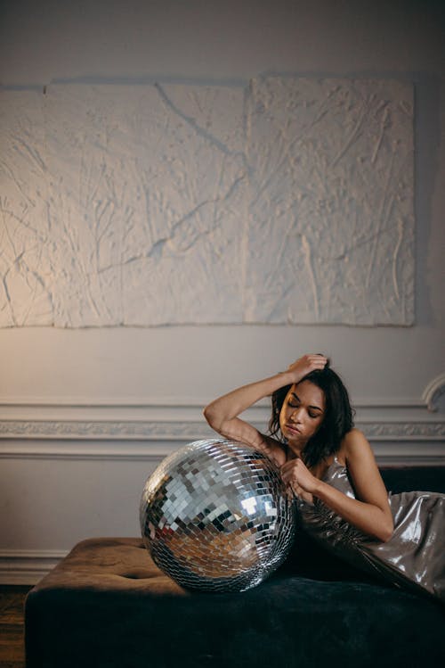 Woman Leaning on Silver Disco Ball