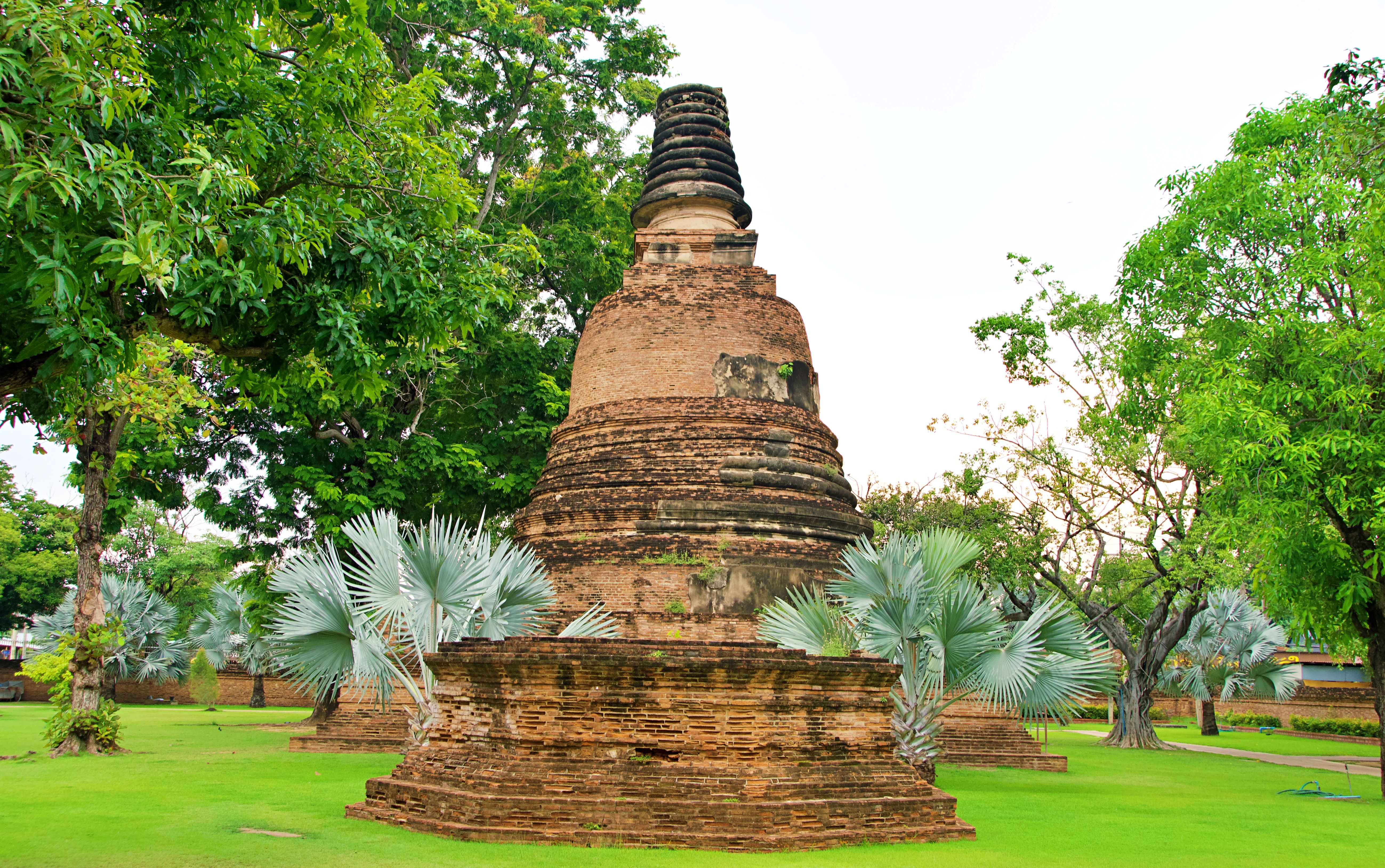 Explore the ancient chedi surrounded by lush greenery in Ayutthaya Historical Park, Thailand.