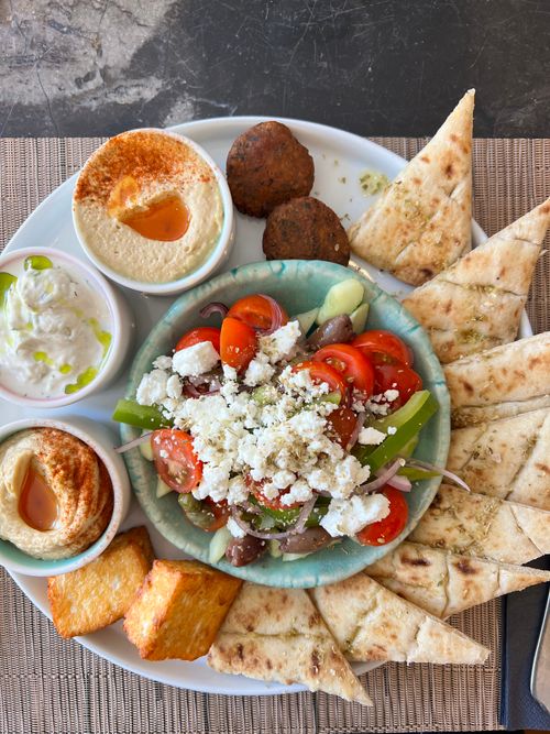 Free Delicious Greek meze platter featuring fresh vegetables, dips, and pita bread, ideal for sharing. Stock Photo