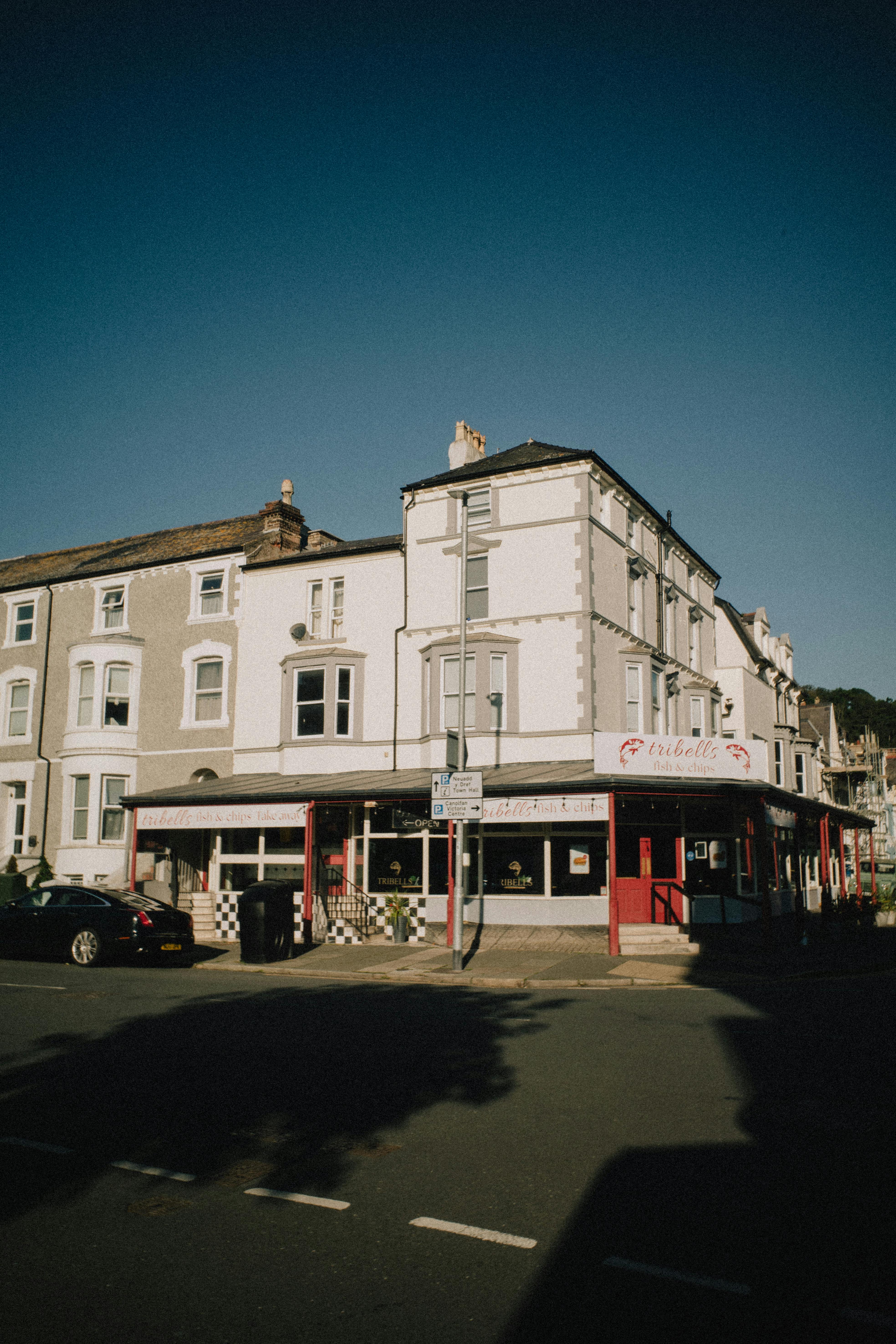 Sunny day street view of Llandudno, highlighting local architecture in warm tones.