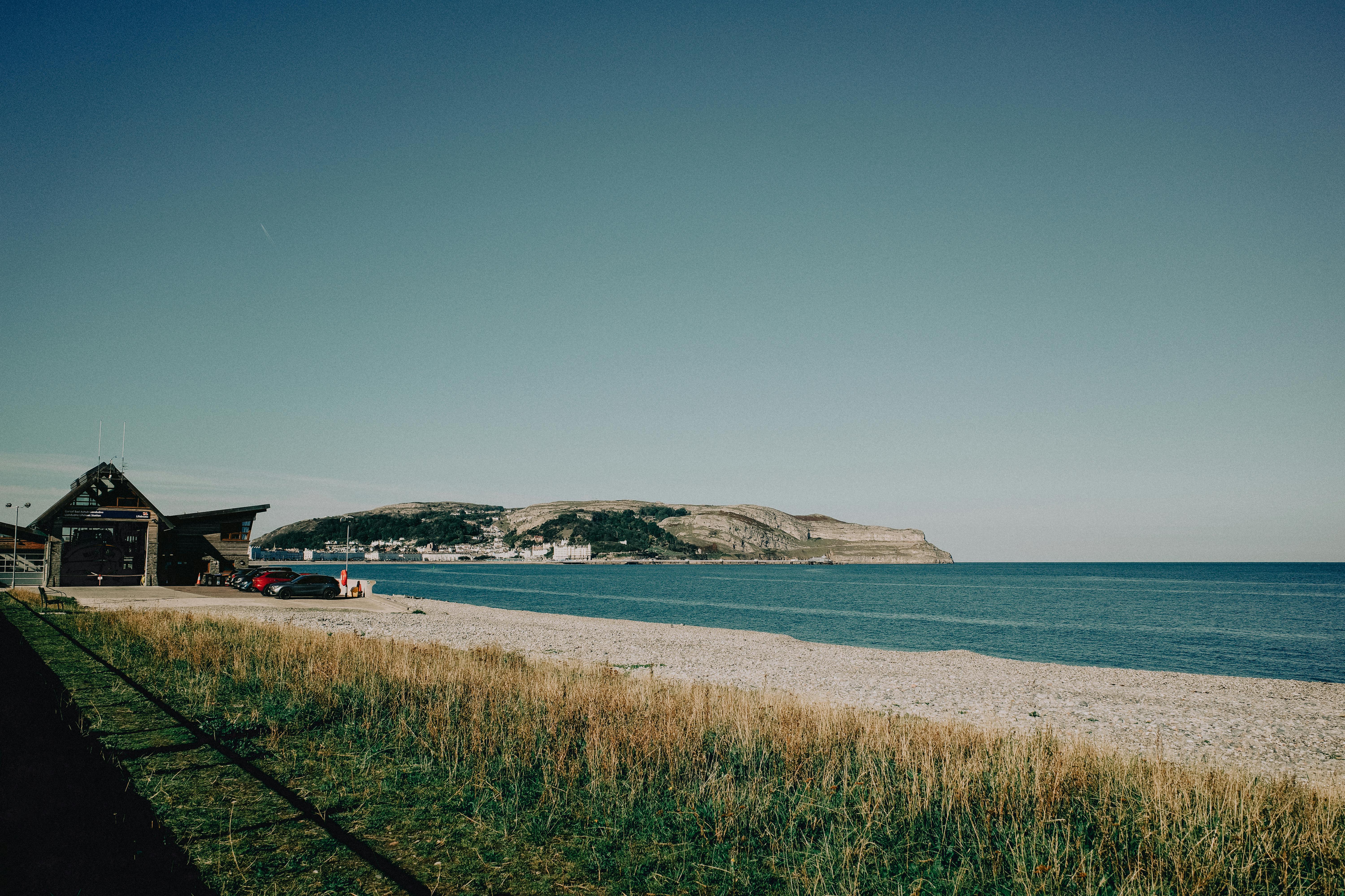 Picturesque landscape of Llandudno beach with clear skies and distant hills in Wales.
