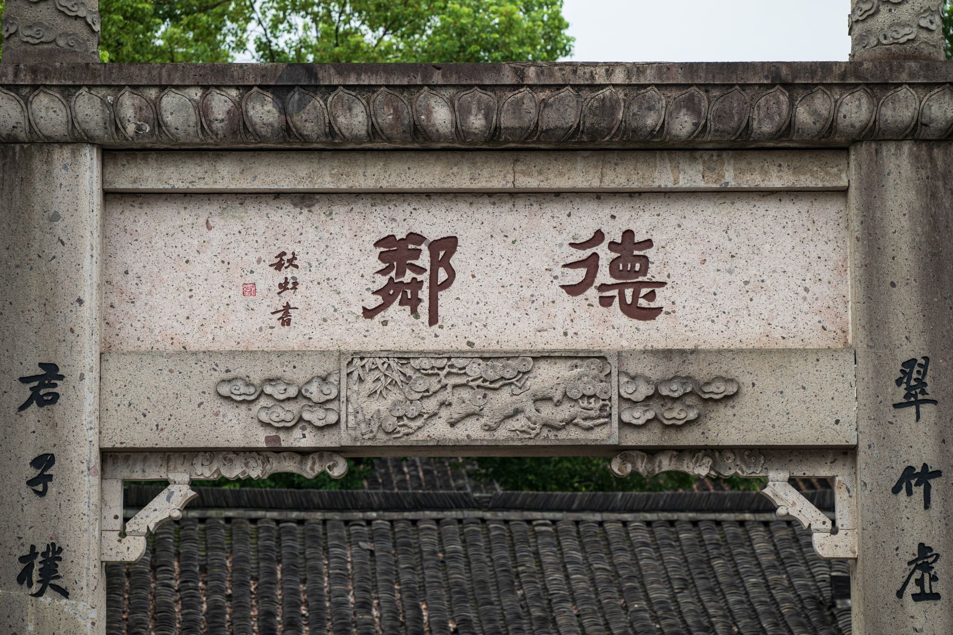 Stone archway featuring intricate carvings and Chinese calligraphy.