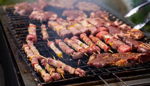 бесплатная Крупный план различных видов мяса и шампуров, жарящихся на гриле, идеально подходит для посиделок на открытом воздухе. Стоковое фото