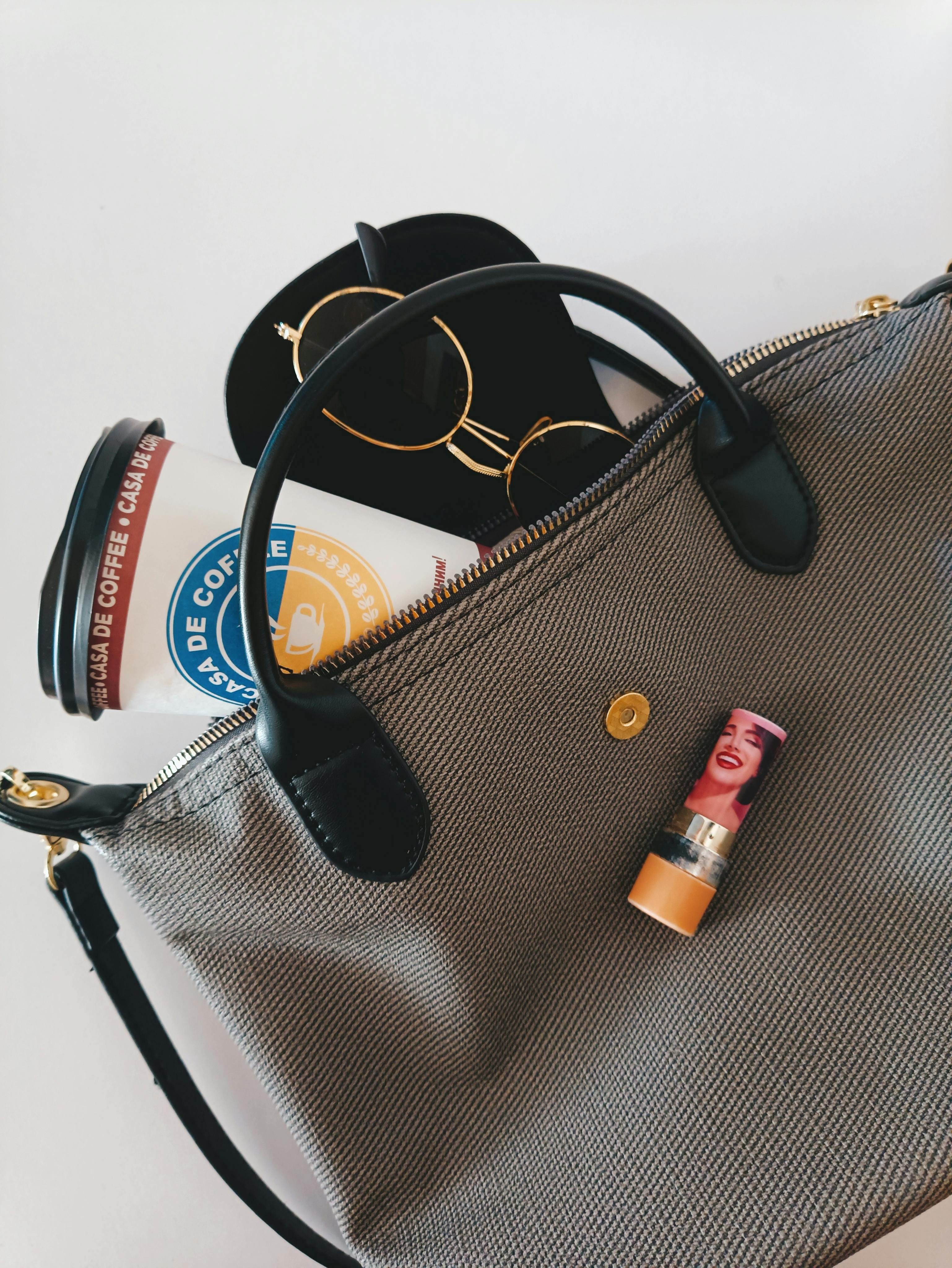 Flat lay of handbag essentials including grooming items