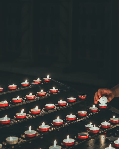 Фотография зажженных вотивных свечей в мелком фокусе