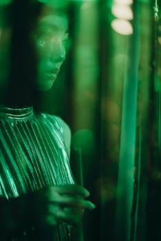 在绿色灯光下，一位手持香槟杯的女子肖像显得时尚精致